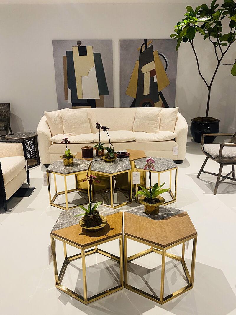 A photo containing a sofa, chairs, and accent tables accessoried each a mix of textures between stone, metals, upholstered and wood.